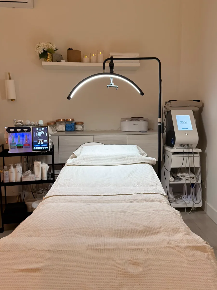 Cabina de estética del salón, con la camilla preparada, la lámpara de luz y la aparatología facial