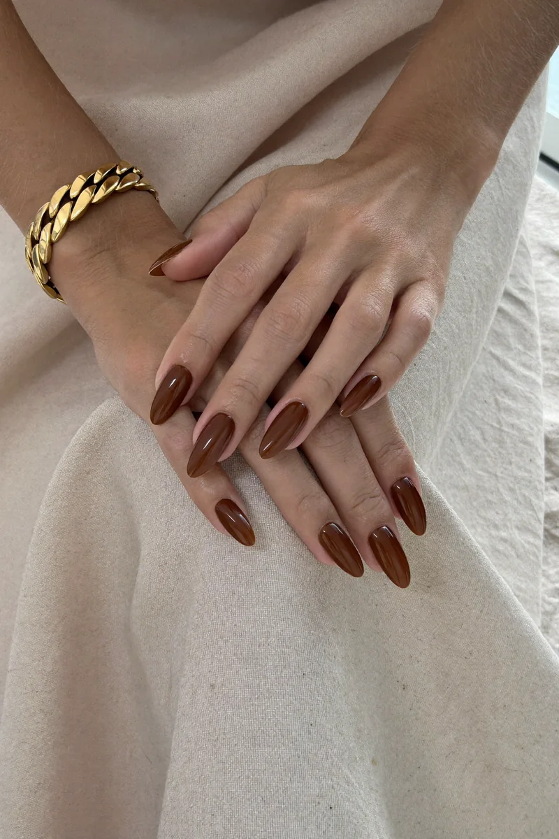 Manicura editorial en tonos moka sobre lino — imagen ilustrativa